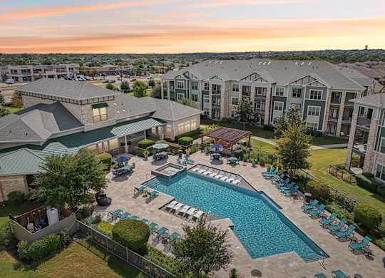 A large outdoor swimming pool surrounded by lounge chairs and umbrellas.at North Creek, Hutto