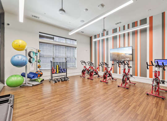 A gym with exercise equipment and a TV.at North Creek, Hutto, TX, 78634