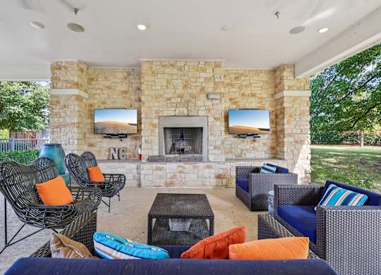 A patio with a stone fireplace and a TV mounted above it.at North Creek, Hutto