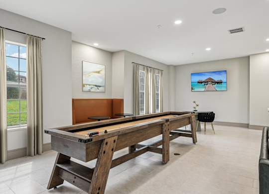 A pool table in a room with a television on the wall.