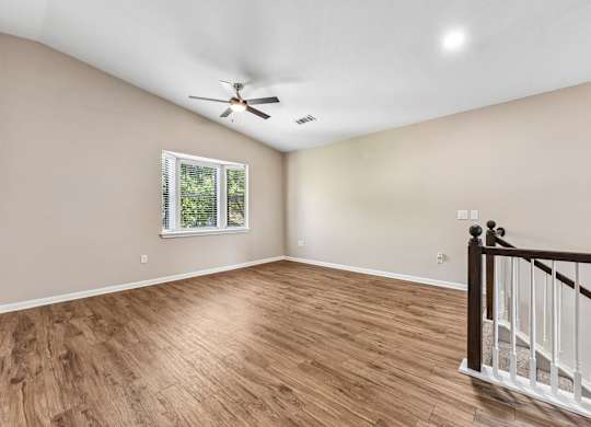 A room with a window and a ceiling fan.