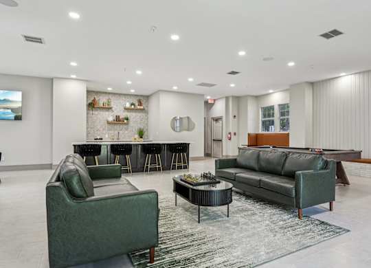 A living room with a green couch, a black coffee table, and a television.