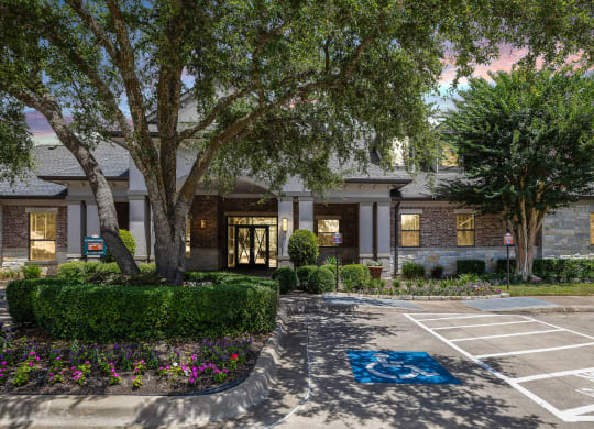 a parking lot in front of a building with trees at The Vista on Brodie, Austin