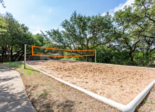 a volleyball court at the whispering winds apartments in pearland, tx at The Verandah, Austin, TX, 78726