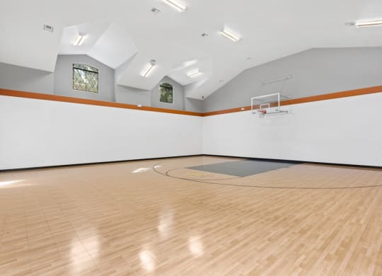 a large white room with a basketball hoop and a hardwood floor at The Verandah, Austin, Texas