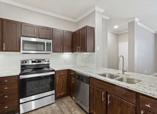 a kitchen with dark wood cabinets and white countertops at The Verandah, Texas