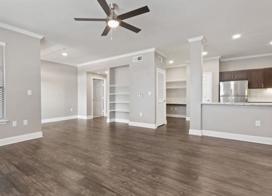 a living room with a ceiling fan and a kitchen in the background at The Verandah, Austin, 78726