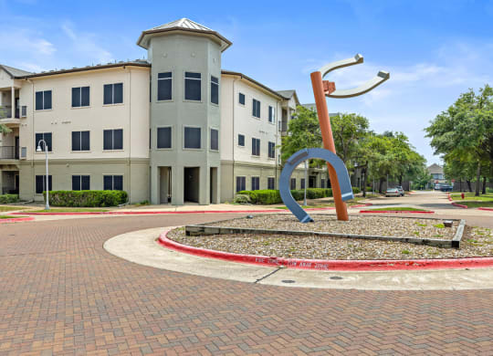 a large sculpture in front of a building at Artisan Apartments & Shops, Texas