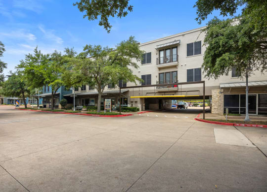 a building with a parking lot in front of it at Artisan Apartments & Shops, Austin, TX