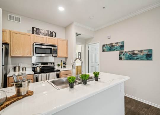 A kitchen with a white counter top and wooden cabinets.