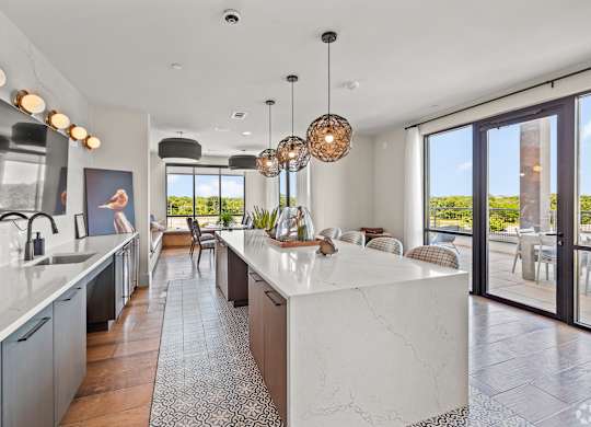 A modern kitchen with a large island and a view of the outdoors. at Aurora Watson Branch, Texas