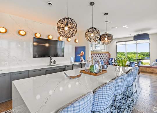 A modern kitchen with a marble countertop and blue chairs. at Aurora Watson Branch, Mansfield, 76063