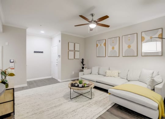 a living room with a white couch and a ceiling fan at The Vista on Brodie, Austin