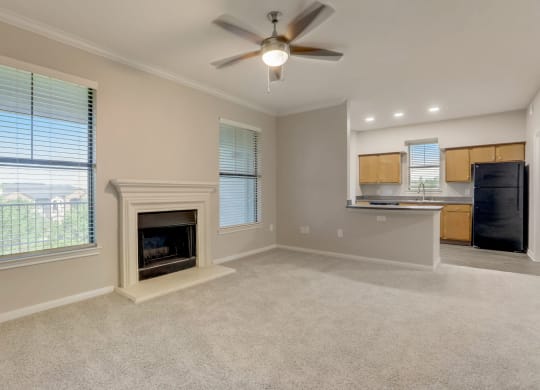 an empty living room with a fireplace and a kitchen at The Vista on Brodie, Austin, TX, 78745