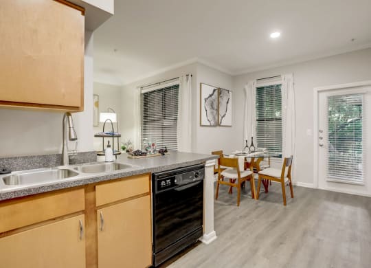 a kitchen and dining room with a table and chairs and a sink at The Vista on Brodie, Austin, TX