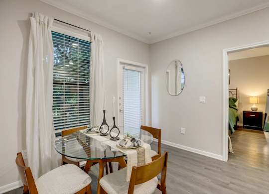 A dining room with a glass table and chairs.