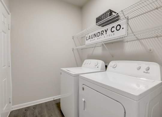 A laundry room with a sign that says