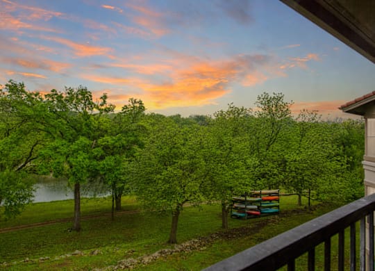 A beautiful view of a lake surrounded by trees and a bench.