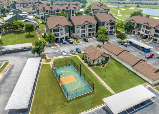 an aerial view of a basketball court in front of apartments