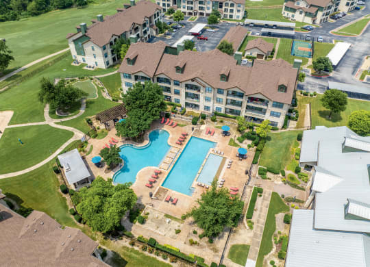 an aerial view of a large swimming pool in a neighborhood with houses