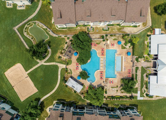 arial view of a swimming pool in a residential neighborhood with houses and trees