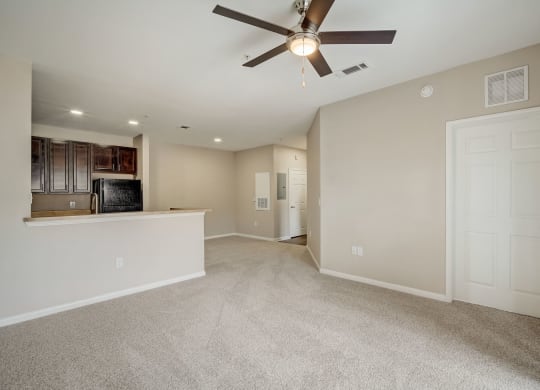 the living room and kitchen in a new home with a ceiling fan at Las Brisas Apartment Homes, Round Rock
