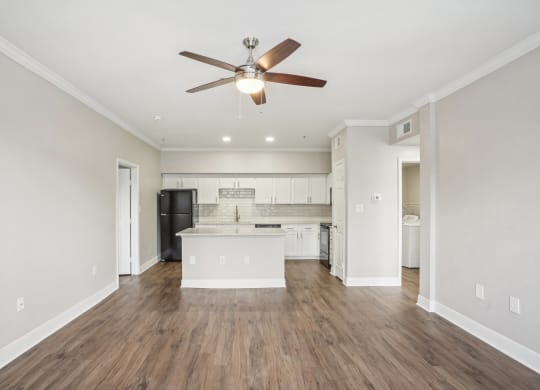 an empty living room and kitchen with a ceiling fan at The Verandah, Texas, 78726