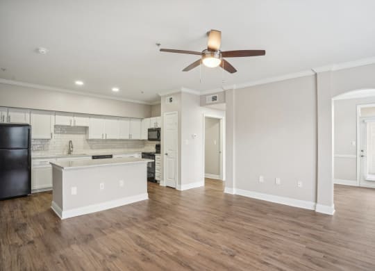 an empty living room and kitchen with a ceiling fan at The Verandah, Austin, TX, 78726