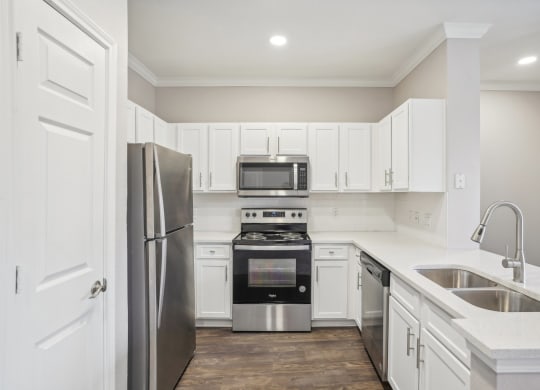 a white kitchen with stainless steel appliances and white cabinets  at The Verandah, Austin, 78726