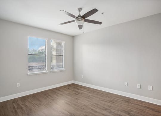 an empty living room with a ceiling fan and a window at The Verandah, Austin, TX