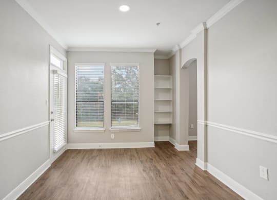 the living room of a new home with white walls and wood flooring  at The Verandah, Austin, TX, 78726