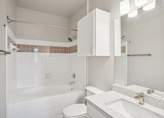 a white bathroom with a tub and a sink and a toilet  at The Verandah, Austin, Texas