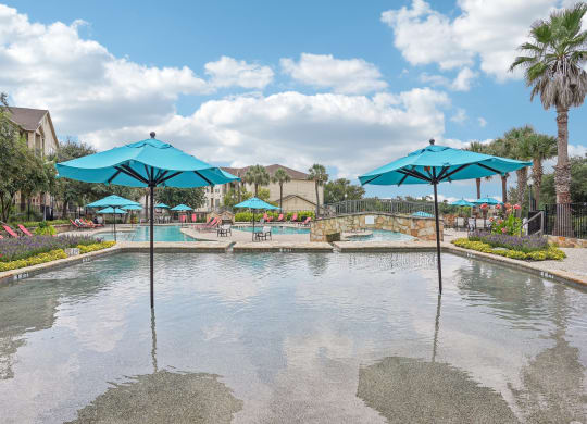 a large pool with umbrellas in the water at the resort  at The Verandah, Austin, Texas