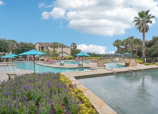 a swimming pool with umbrellas at the resort at The Verandah, Austin