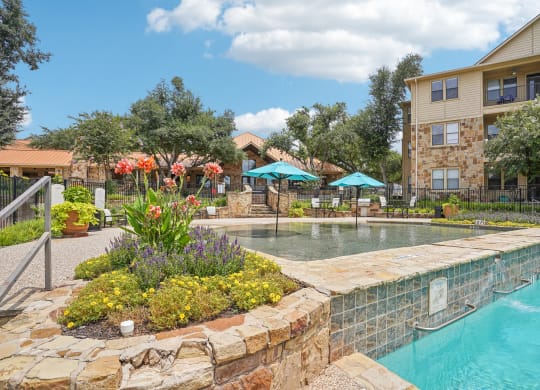 a swimming pool with a building in the background  at The Verandah, Austin, TX, 78726