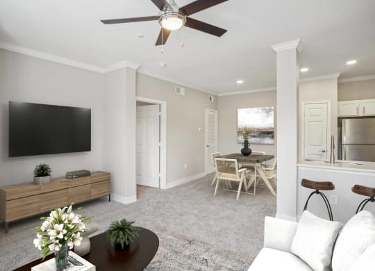 a living room with a ceiling fan and a tv  at The Verandah, Austin, TX