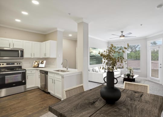 an open kitchen and living room with a large window and a table  at The Verandah, Austin, TX