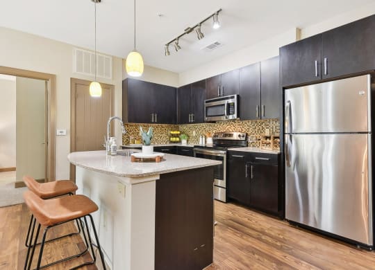 a kitchen with stainless steel appliances and a marble counter top at Lakeline East Apartments, Cedar Park, TX
