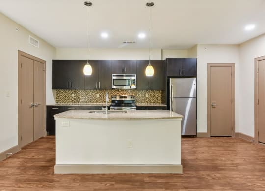 a kitchen with a large island and a stainless steel refrigerator at Lakeline East Apartments, Cedar Park, 78613