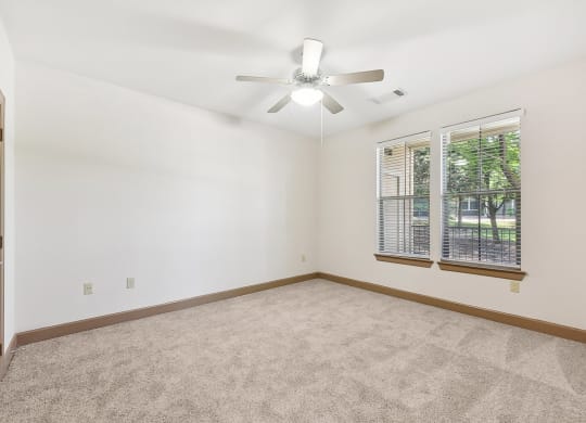 an empty living room with a ceiling fan and a window at Lakeline East Apartments, Texas