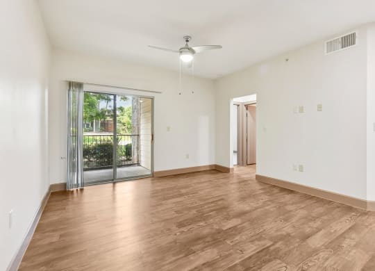 an empty living room with a sliding glass door to a patio at Lakeline East Apartments, Cedar Park