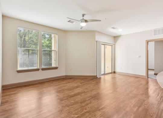 an empty living room with wood floors and a ceiling fan at Lakeline East Apartments, Texas, 78613
