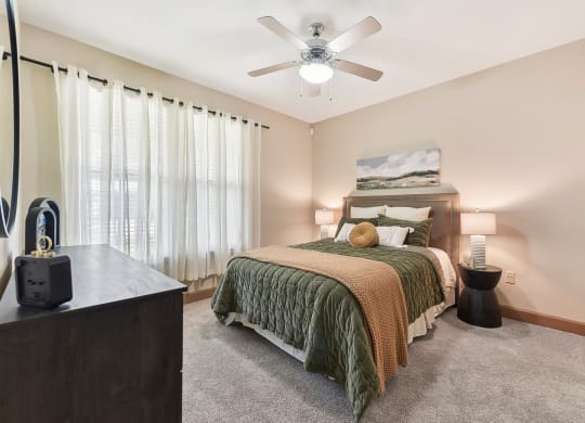 a bedroom with a large bed and a ceiling fan at Lakeline East Apartments, Cedar Park, TX