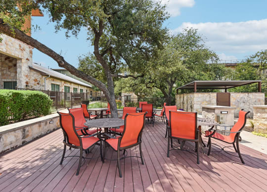 a patio with a table and chairs and a fire pit at Lakeline East Apartments, Cedar Park, TX