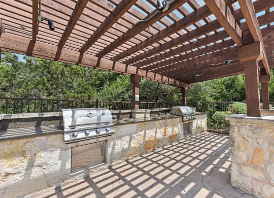 a patio with a barbecue grill and a pergola at Lakeline East Apartments, Cedar Park, 78613
