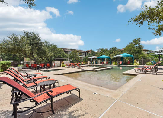 the preserve at ballantyne commons community swimming pool with red benches at Lakeline East Apartments, Texas, 78613