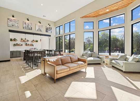 a living room with a couch and a table in front of a large window