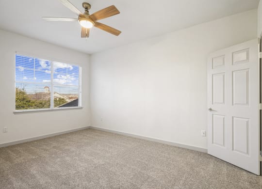 an empty living room with a ceiling fan and a window at The Legends at Eagle Mountain Lake, Fort Worth, Texas