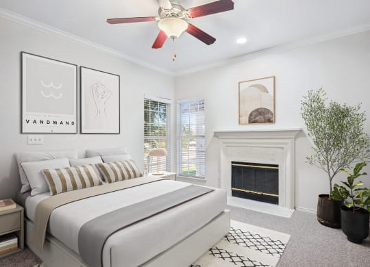 a bedroom with a bed and a fireplace at La Ventura Apartments, Plano, Texas