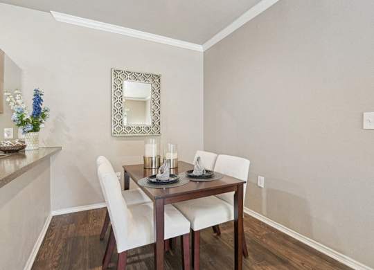 a dining room with a table and chairs and a mirror